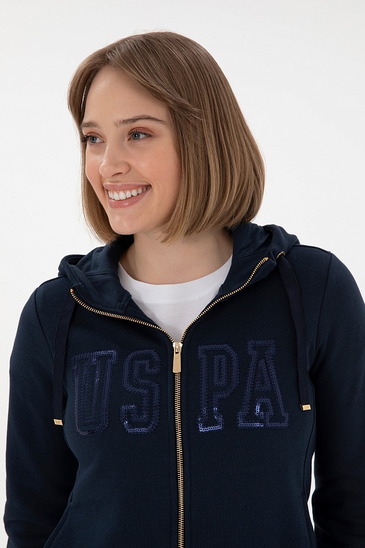Толстовка на молнии с капюшоном от U.S. Polo Assn. — это стильный элемент гардероба, который прекрасно сочетает в себе комфорт и актуальный дизайн. Мягкий материал обеспечивает приятные ощущения при ношении, а капюшон добавляет уют и защищает от непогоды. Элементы молнии позволяют легко надевать и снимать толстовку, а свобода кроя обеспечивает хорошую подвижность и удобство. Этот предмет отлично подходит для повседневного использования, а также активного отдыха, позволяя уверенно выражать свой индивидуальный стиль.<br />
<br />
Цвет: темно-синий<br />
Состав: <br />
Рост: ; Параметры: ; Размер на модели:  - G082SZ0820SW0125 Толстовка жен. (VR033, S)